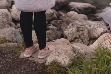 Low section of woman standing on rock