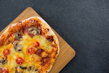 Overhead view of pizza on wooden plate