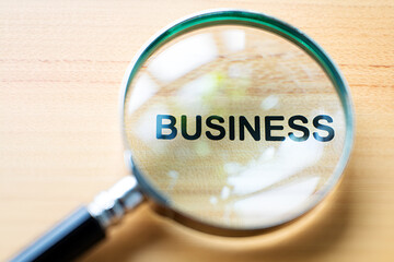 Magnifying glass over word business on wood lens