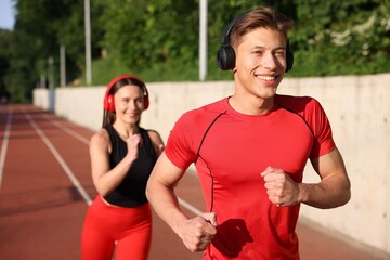 Sporty couple running at stadium, selective focus
