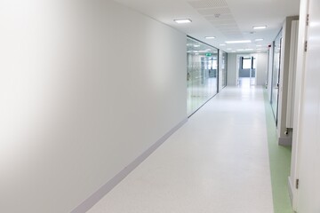 Naklejka premium Flat design corridor is stretching into distance with glass panels, doors, radiator, exit sign