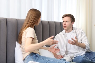 Woman and man fighting on bed at home