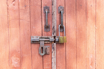 Gate rustic antique metallic old door wood red details shapes textured symmetry locks. Old Unlocked Padlock with key. Used to lock door or fence of house.