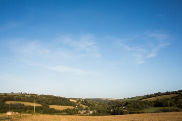 Flat design art is showing harvested field with utility poles, fence posts, hedgerows, stone barns