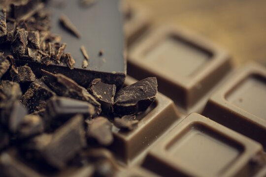 Naklejki 3D render is showing broken dark chocolate chunks resting atop milk chocolate bar with shallow blur