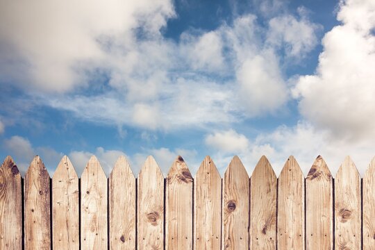 Fototapeta Flat design illustration is featuring weathered wooden picket fence against cloudy blue sky