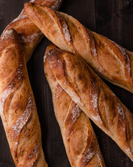 Freshly Baked French Baguettes on Rustic Wooden Surface, Golden Crusty Baguettes on Dark Background, Classic Bakery Style Baguettes on Dark Wood, Homemade Baguettes on Wooden Table