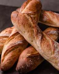 Homemade Baguettes on Wooden Table, Freshly Baked French Baguettes on Rustic Wooden Surface, Golden Crusty Baguettes on Dark Background, Crusty French Baguettes Stacked Together