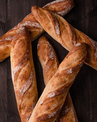 Freshly Baked French Baguettes on Rustic Wooden Surface, Close-Up of Artisan Baguette Bread Loaves, Classic Bakery Style Baguettes on Dark Wood, Fresh Rustic Baguettes with Crispy Crust