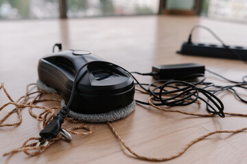 Close-up of robotic window cleaner docking on wooden floor, preparing for autonomous high-rise...