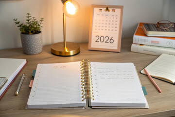 Planner with a golden lamp and 2026 calendar on a desk
