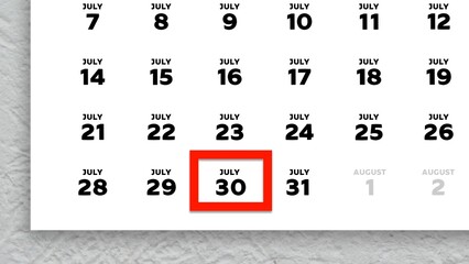 Close-up of the date July 30th marked with a red cursor on the wall calendar 2025