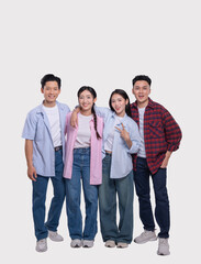 Obraz premium Diverse group of young adults in casual attire smiling and embracing each other in a studio setting