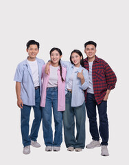 Four cheerful friends stand shoulder to shoulder radiating positivity in their casual attire