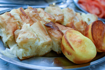 Plates placed on the table, finely chopped and served dried meat, small salty rolls and salad as a topping