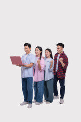 Obraz premium Excited group of young adults celebrating success viewing a laptop with joyful expressions