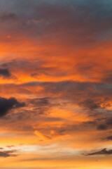 The sky is orange and the clouds are white. Phone wallpaper. Vertical background.