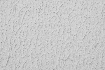 Close up of textured white color painted wall with rough stucco, plaster wall texture. Vibrant background, wallpaper, backdrop, design element.
