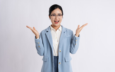 Enthusiastic woman in business attire presents with open palms against a clean backdrop