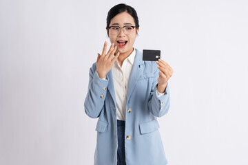 Excited woman in a blue blazer holding up a credit card with a surprised expression on her face