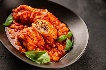 Stuffed cabbage tomato sauce with beans meat, cabbage, fresh delicious gourmet food background on the table rustic food top view copy space
