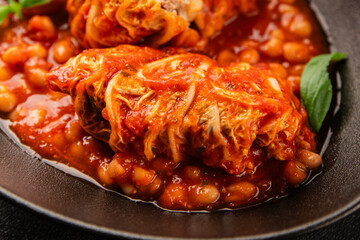 Stuffed cabbage tomato sauce with beans meat, cabbage, fresh delicious gourmet food background on the table rustic food top view copy space