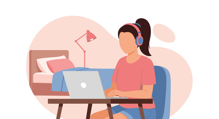 Fototapeta premium A young woman with headphones is working on her laptop at a desk in her bedroom, participating in a virtual meeting or online class from home.