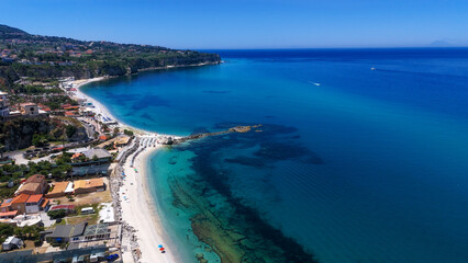 Fototapeta premium Aerial view of Tropea, a charming coastal town in Calabria, Italy, highlighting its stunning turquoise waters, beautiful beach, and picturesque coastline