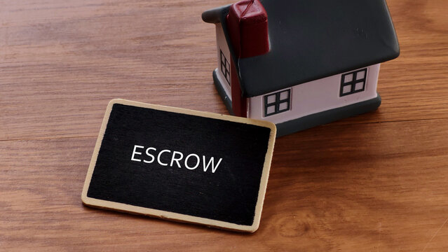 Escrow Concept with Miniature House and Blackboard