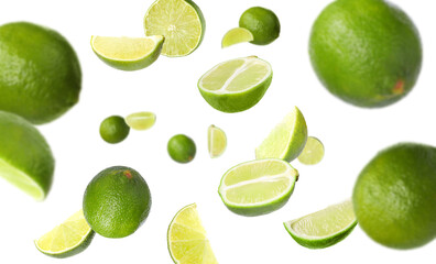 Fresh ripe limes flying on white background