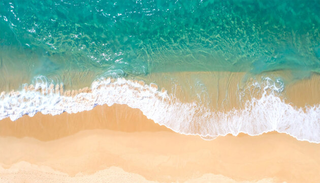 Ocean waves meet a pristine sandy beach from an aerial perspective