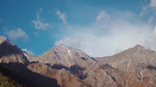 Clouds above the dried Himalayan mountain peaks during the summer season as seen from Chitkul village in Kinnaur district, Himachal Pradesh, India. Scenic view of Himalayas in summer season.