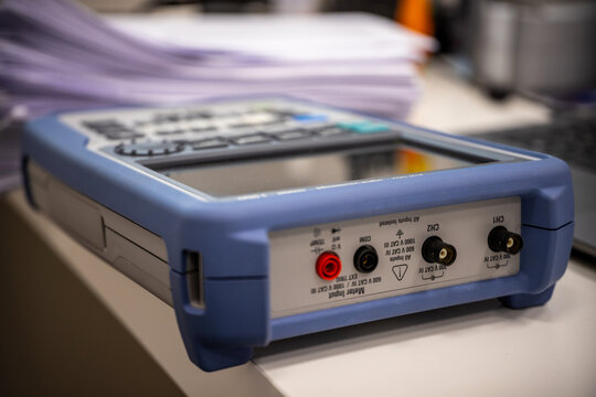 Close-up of a professional electrical measurement device resting on a lab bench.