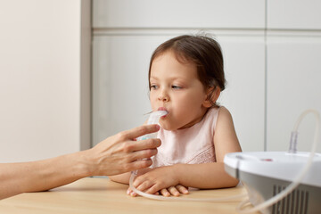 mother makes inhalation to toddler child girl at home
