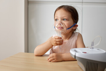 cute little toddler girl making inhalation with nebulizer