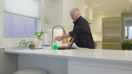 Senior Man Washing Hands at Kitchen Sink in Bright Modern Home, Ontario, Canada - Powered by Adobe
