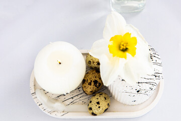 Decorative tray with candle quail eggs and flower for spring celebration or event