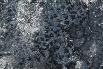 Intricate patterns formed by dried ink on textured surface under natural light