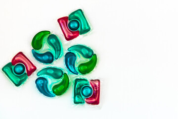 Colorful laundry detergent pods arranged creatively on a light background