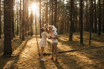 
A joyous child on father's shoulders, her mother is nearby looking up, all smiling in a...