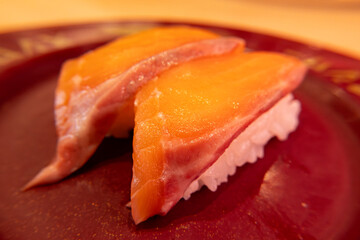 Close-up shot of freshly prepared salmon sushi served on a ceramic plate inside a traditional Japanese restaurant