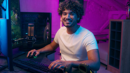 Indian Arabian Latino man playing computer pc technology game cyberspace tournament esport...