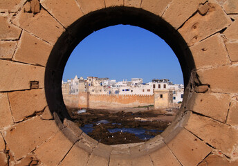 Morocco Essaouira Round window in the fortification of the historical harbour, framing a view of...
