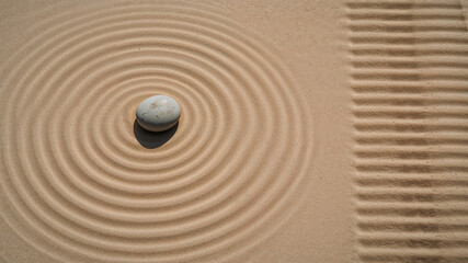 Stone creating concentric circles in sand representing meditation and mindfulness