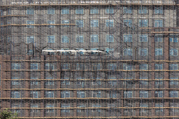 scaffolding covering over building facade during crane construction built infrastructure industrial repair real estate flushing queens new york city renovation cleaning clean 