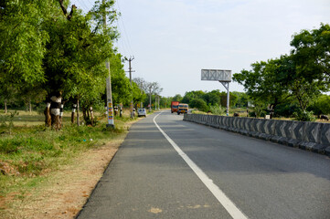 Quiet road lined with trees in rural area of India