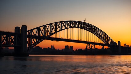Naklejka premium Majestic steel bridge at dusk reflects golden light on calm water under a gradient twilight sky.
