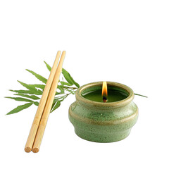 A small, green ceramic candleholder with a lit candle rests beside bamboo chopsticks and greenery