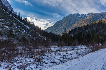 vista panoramica su di un ambiente naturale di montagna in inverno, tra le catene montuose alpine del Friuli Venezia Giulia, nel nord Italia, con cielo parzialmente nuvoloso