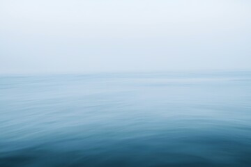 Obraz premium Serene ocean view with smooth waves and soft sky for backgrounds and minimalist designs